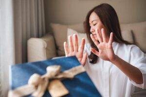 A woman refusing a present she didn’t want as it reminds her of Radiation Fibrosis Syndrome, which she experienced after Radiation Therapy.