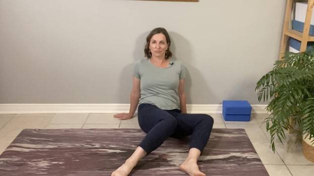 Beth Hoag, Physiotherapist, on the floor showing the motion of windshield wipers with her legs bent and going to one side. An example of a hip stretch after pelvic radiation therapy.