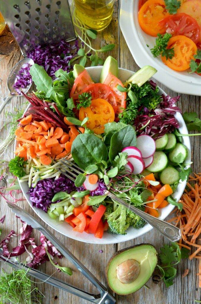 Fibre-rich foods, which are good to aid constipation, are served in an assortment of colours in a bowl on a wooden table.