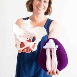 Beth Hoag is wearing a blue tank top and holding pelvic health anatomy models.